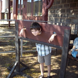 Kyle in the stocks, Connor watching on